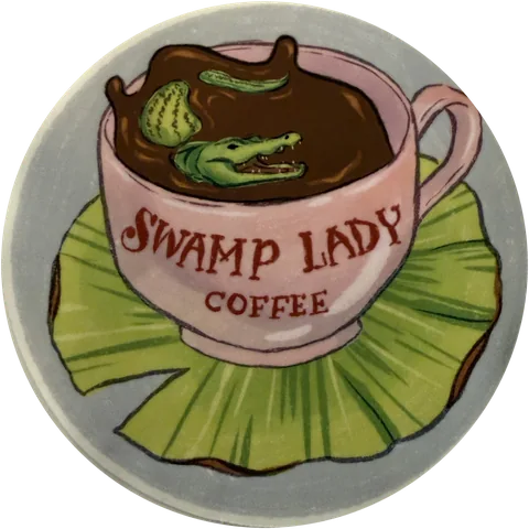 Swamp Lady Coffee badge: a gator swimming in a pink teacup of coffee on a lily pad